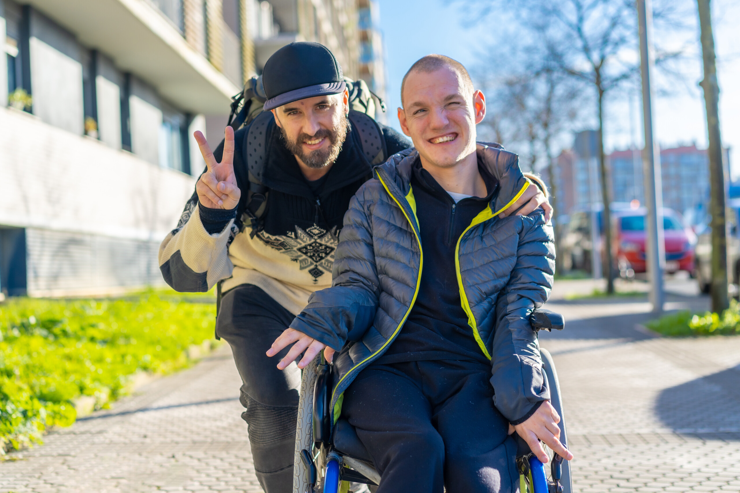 Portrait of a disabled person in a wheelchair with a friend, normality of disabled people A man standing next to a friend in a wheelchair